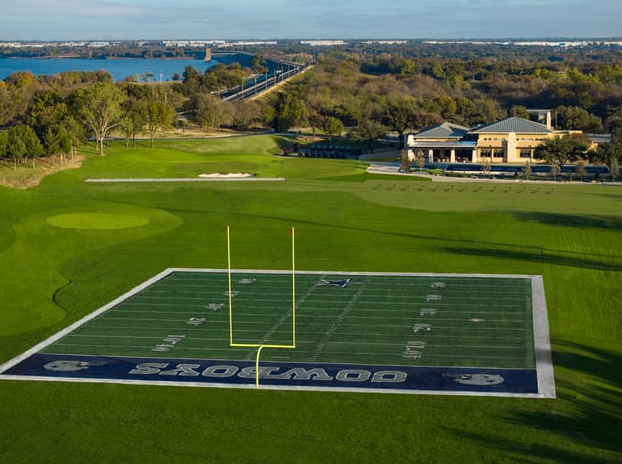 Cowboys Golf Club driving range with Cowboys-themed field and uprights — Photo: Arcis Golf